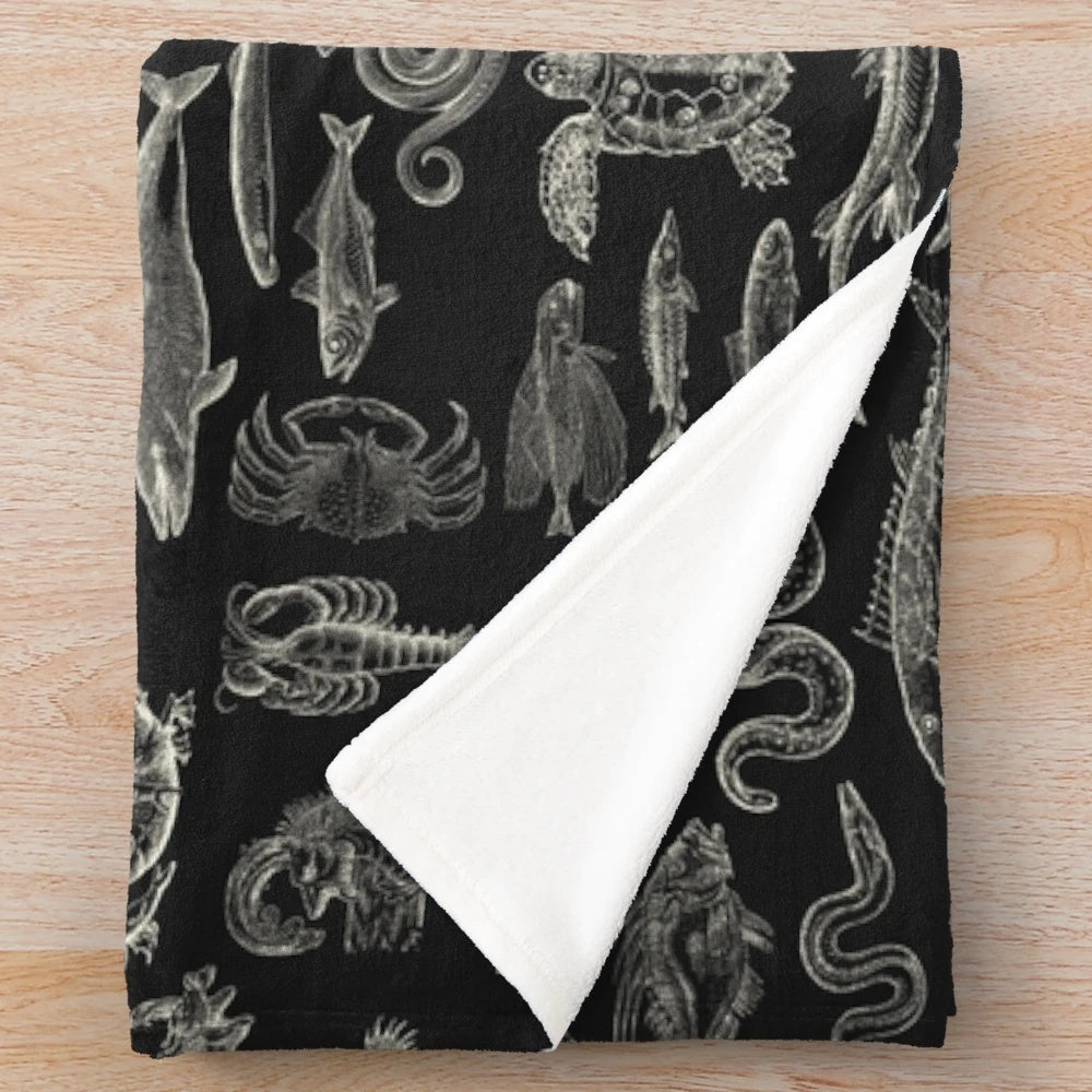 Plush white blanket with illustrated sea creatures including octopus, whale shark, and sea turtle