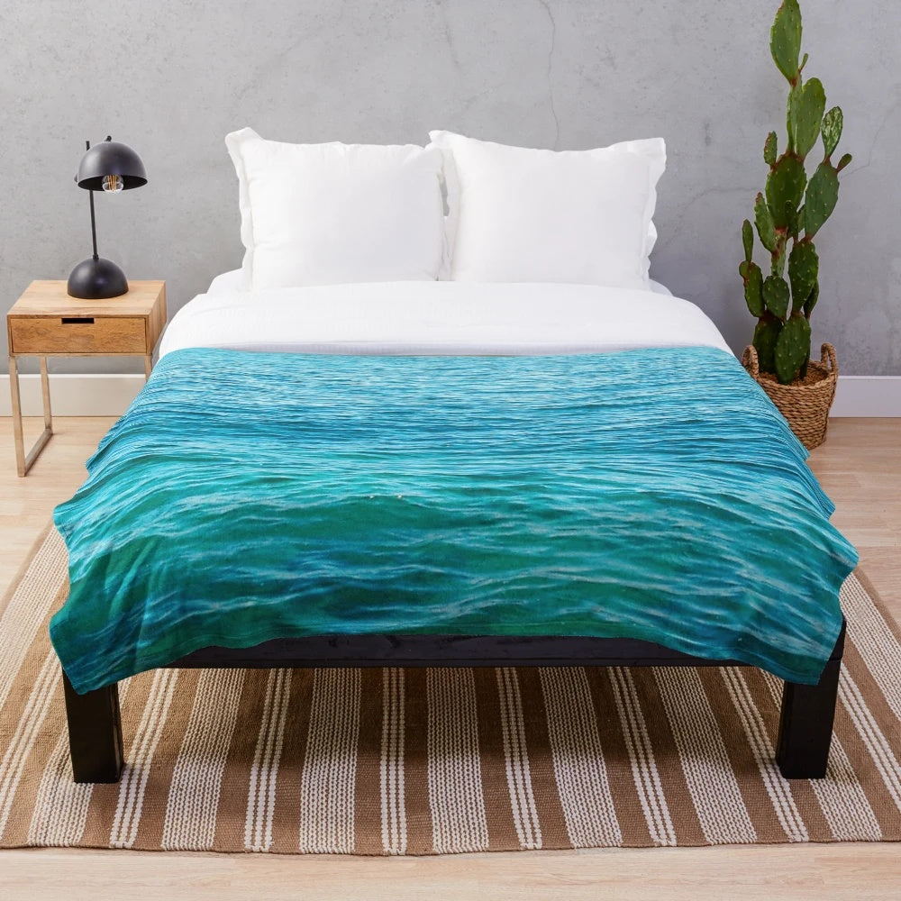 Turquoise plush blanket with ocean waves and water ripples design