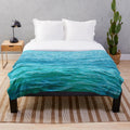 Turquoise plush blanket with ocean waves and water ripples design
