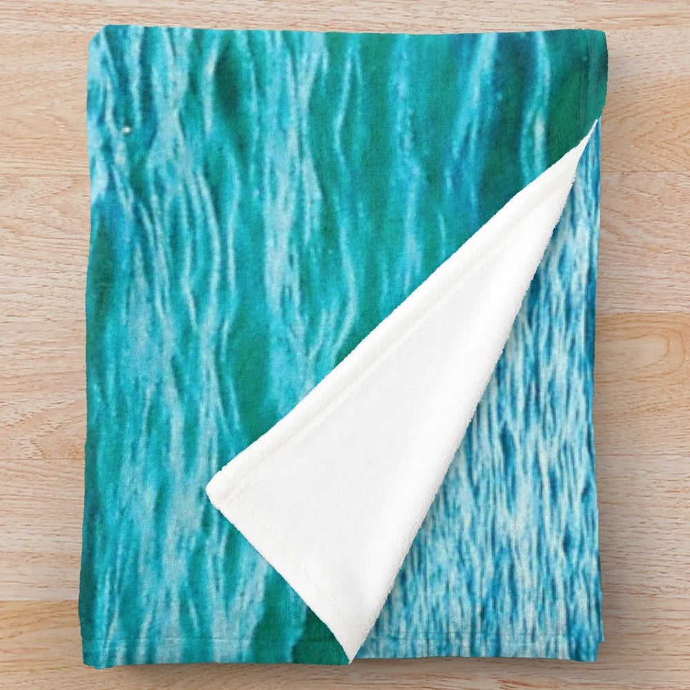 Turquoise plush blanket with ocean waves and water ripples design