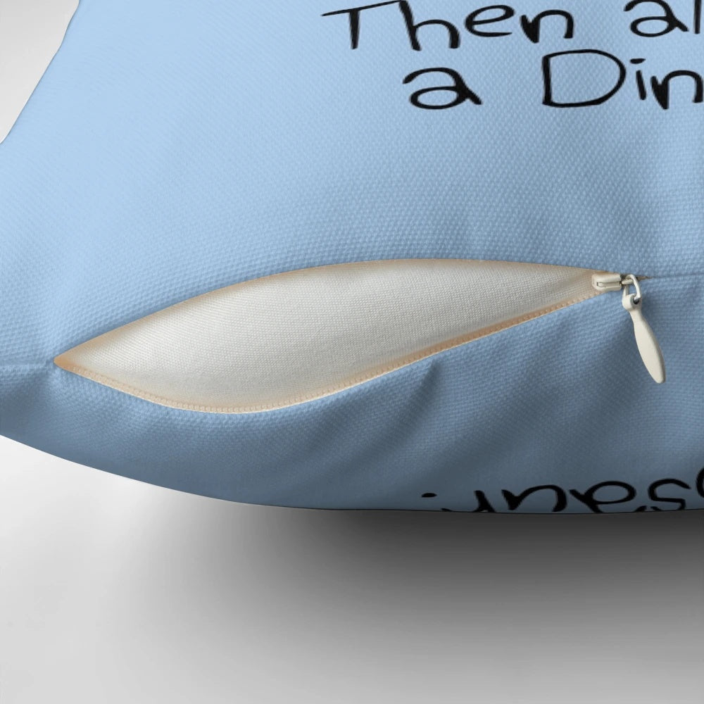 A plush, colorful dinosaur pillow with the text "Always Be Yourself, Unless You Can Be A Dinosaur"