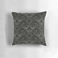 A decorative throw pillow featuring a detailed stegosaurus dinosaur design in a vintage lace pattern with black and grey colors.