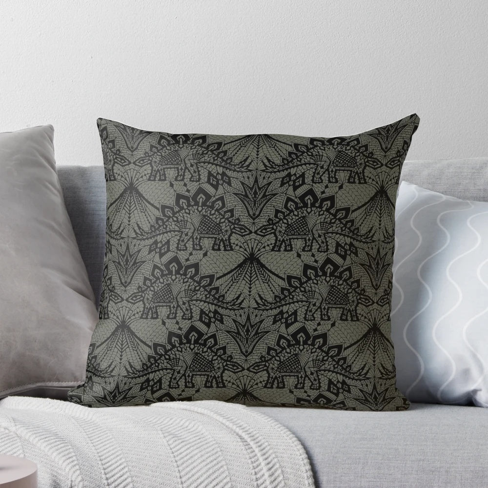 A decorative throw pillow featuring a detailed stegosaurus dinosaur design in a vintage lace pattern with black and grey colors.