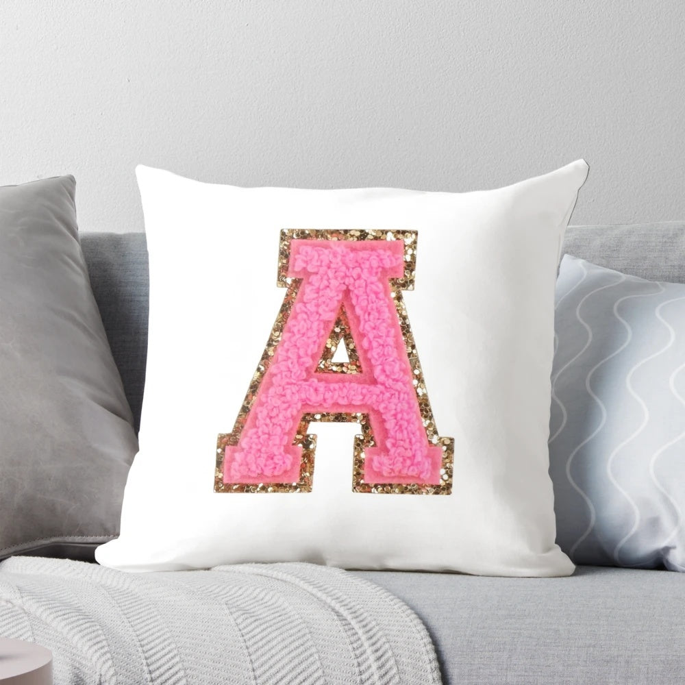A pink pillow with a preppy letter design, perfect for a stoney clover lane inspired room.