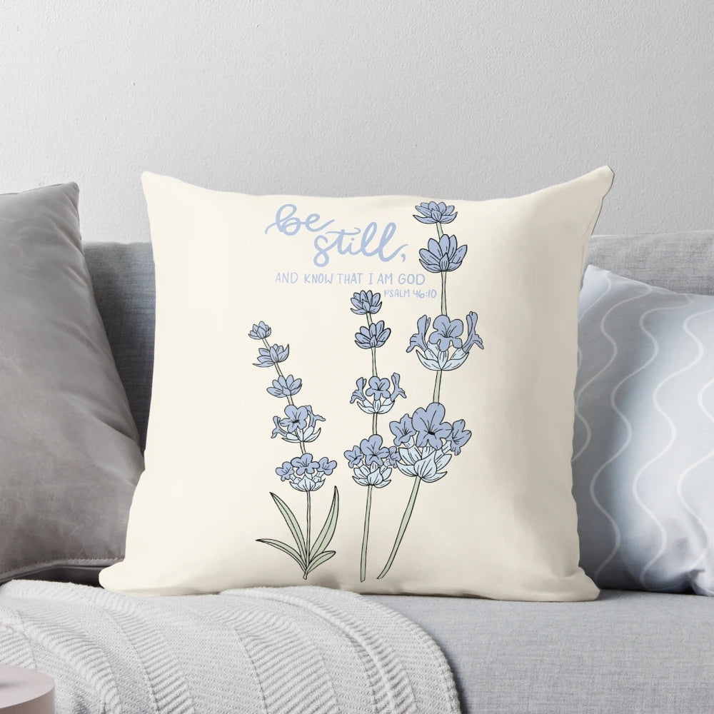 Blue and white hydrangea flowers with the Bible verse "Be still, and know that I am God" from Psalm 46:10 printed on a white pillow.