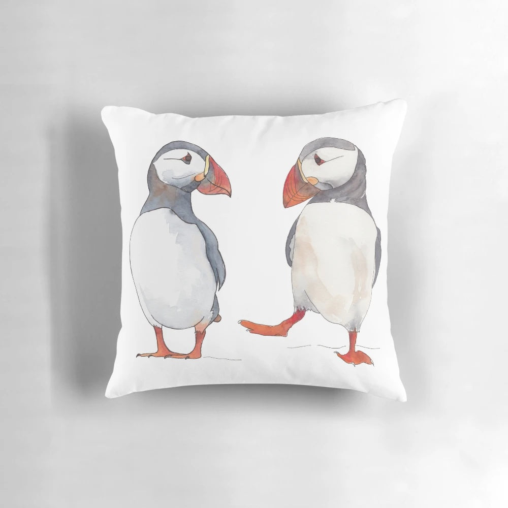 Illustration of puffins dancing and tapping on a decorative pillow