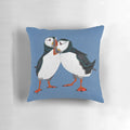 A pair of puffins in shades of blue on a decorative linen pillow.