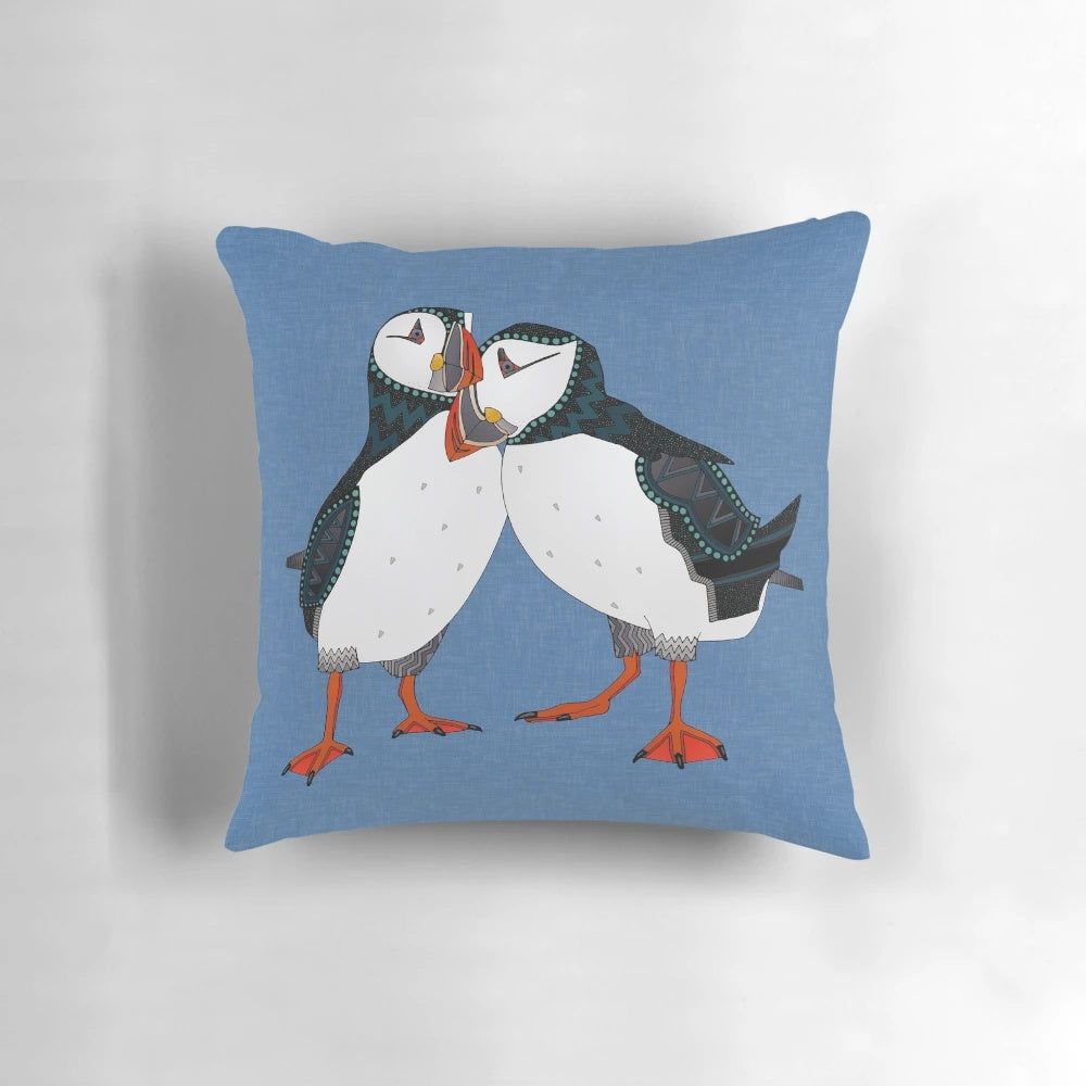 A pair of puffins in shades of blue on a decorative linen pillow.