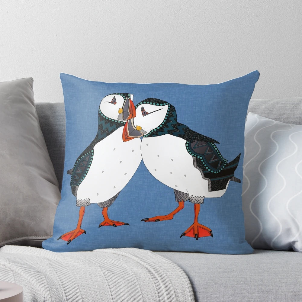 A pair of puffins in shades of blue on a decorative linen pillow.