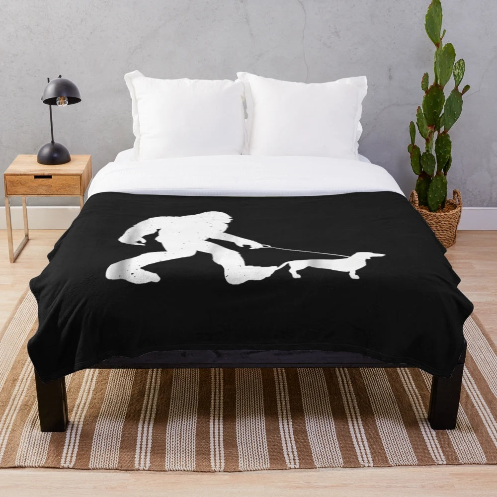Bigfoot walking a dachshund wiener dog on a plush blanket