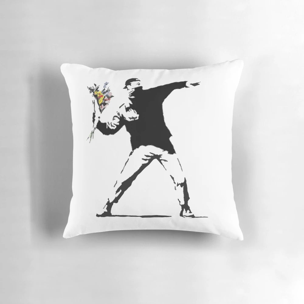 Throw pillow featuring a stencil design of a person throwing a flower, inspired by the Banksy "Flower Bomber" street art.