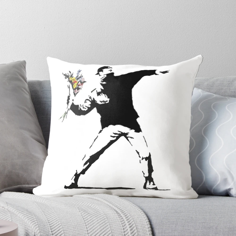 Throw pillow featuring a stencil design of a person throwing a flower, inspired by the Banksy "Flower Bomber" street art.
