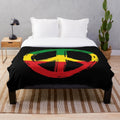 Plush black blanket with peace symbol in rastafarian colors
