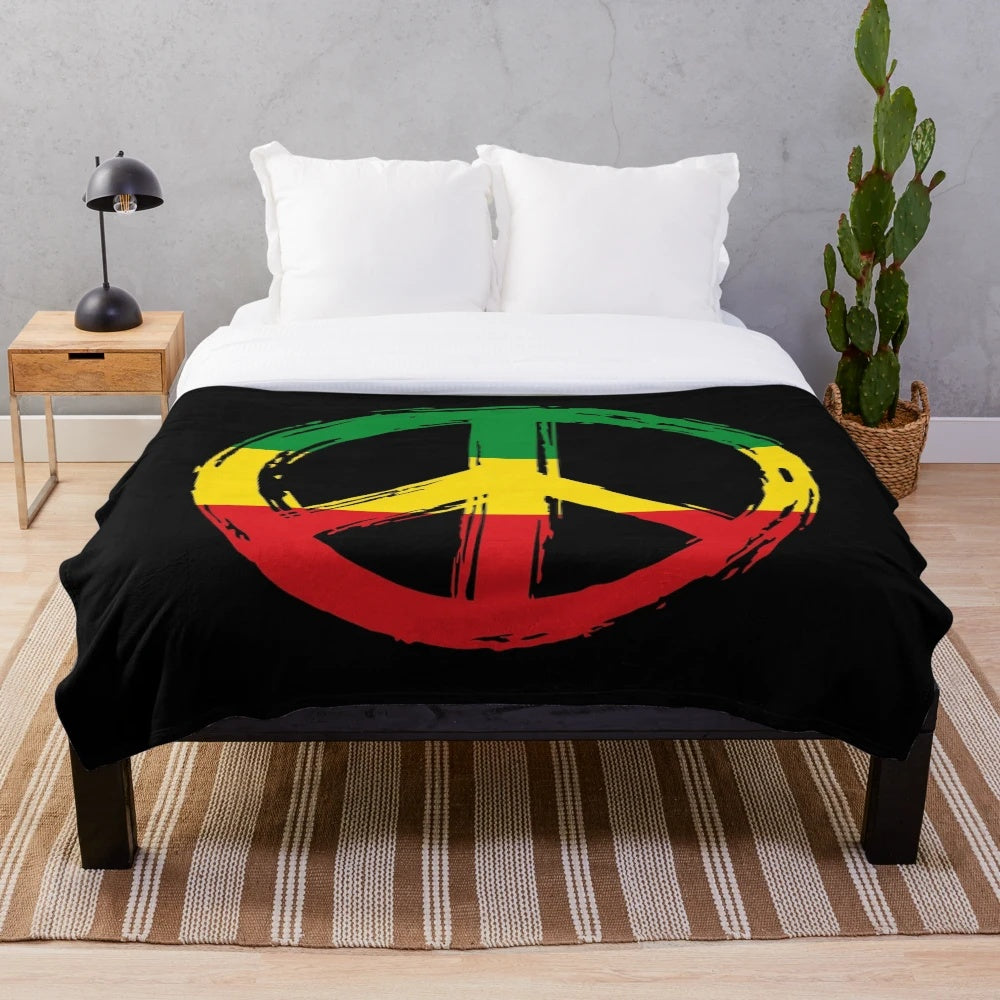 Plush black blanket with peace symbol in rastafarian colors