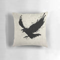 A black and white pillow with a sketch-style raven design, surrounded by splatters and drips