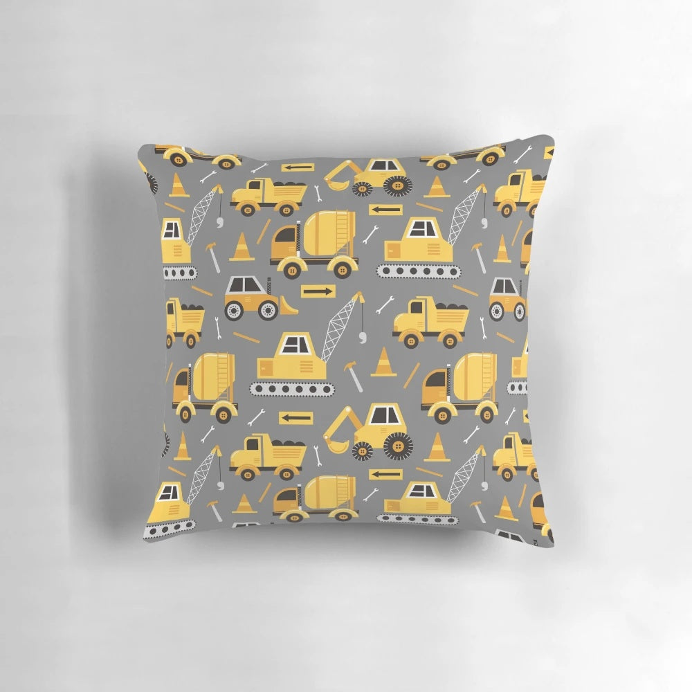 Gray decorative pillow featuring construction trucks and vehicles