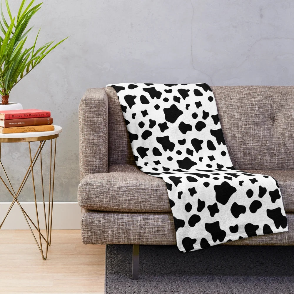 Close-up of a black and white cow spots pattern plush blanket