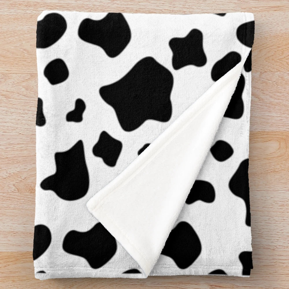 Close-up of a black and white cow spots pattern plush blanket