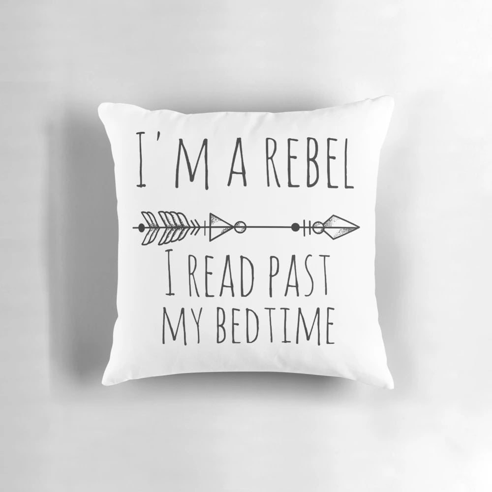 A plush pillow with the text "I'm A Rebel - I Read Past My Bedtime" and arrows, designed for readers who love to stay up late with their books.