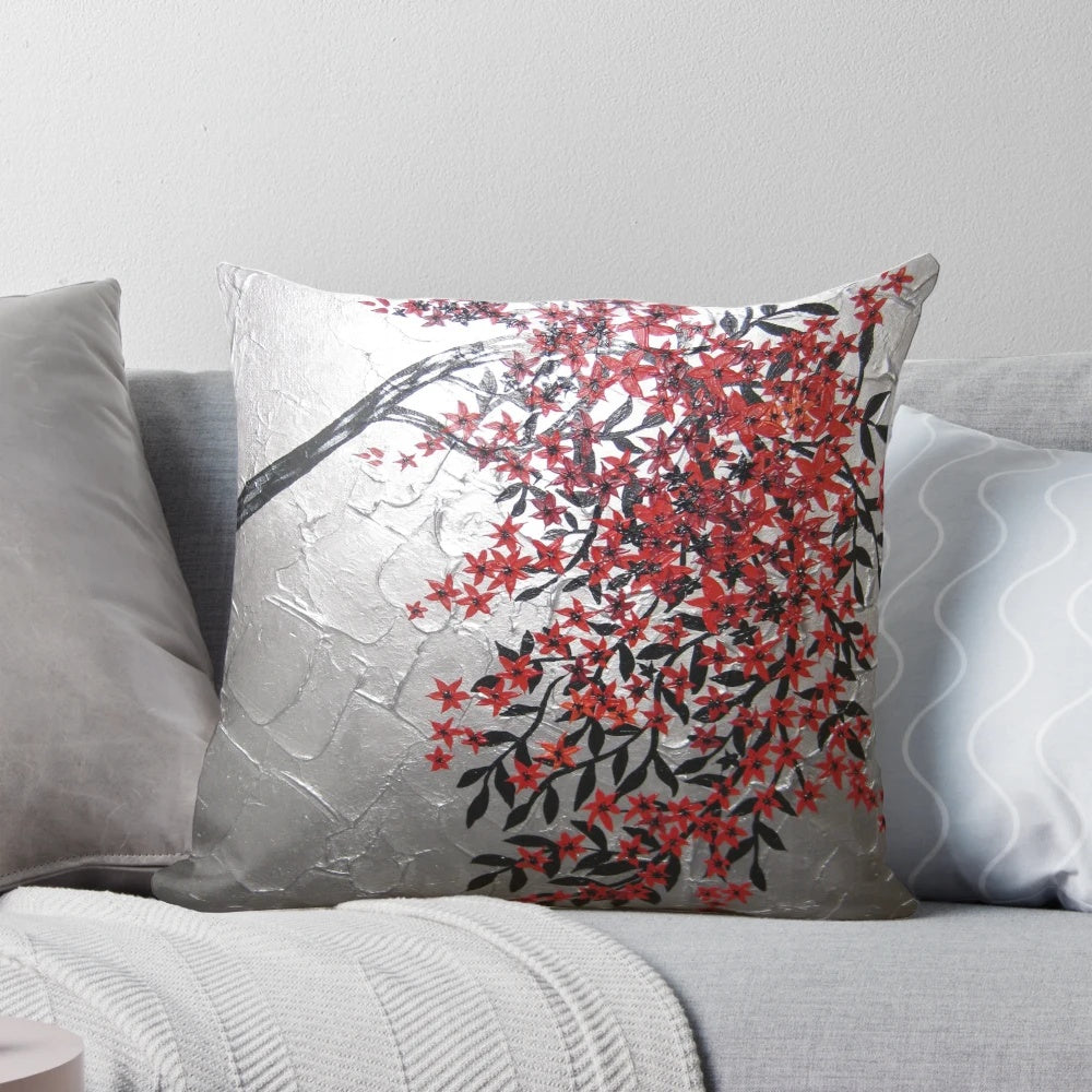 Red, black, and silver cherry blossom tree art design on a decorative accent pillow