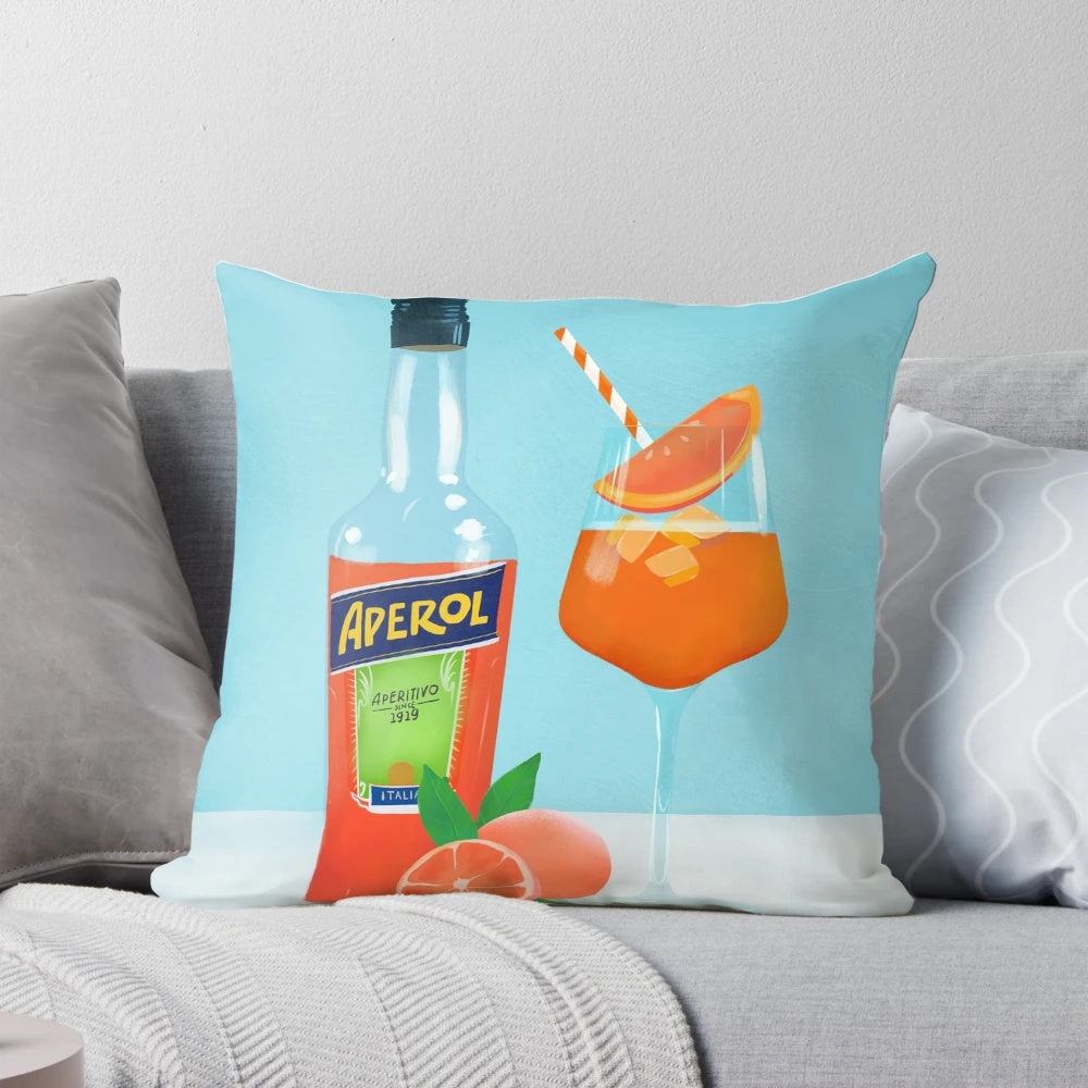 Decorative pillow featuring a vibrant illustration of an Aperol spritz cocktail, with orange slices and ice