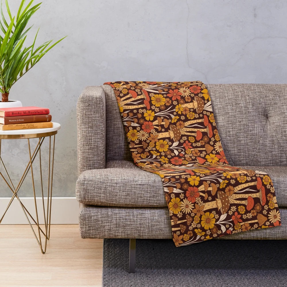Retro 1970s inspired plush blanket with brown, orange, and yellow mushrooms and flowers