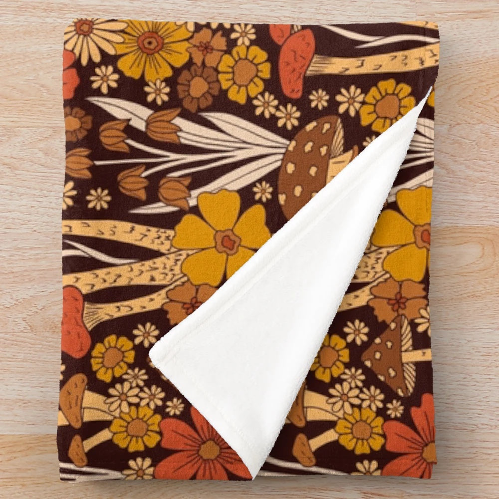 Retro 1970s inspired plush blanket with brown, orange, and yellow mushrooms and flowers