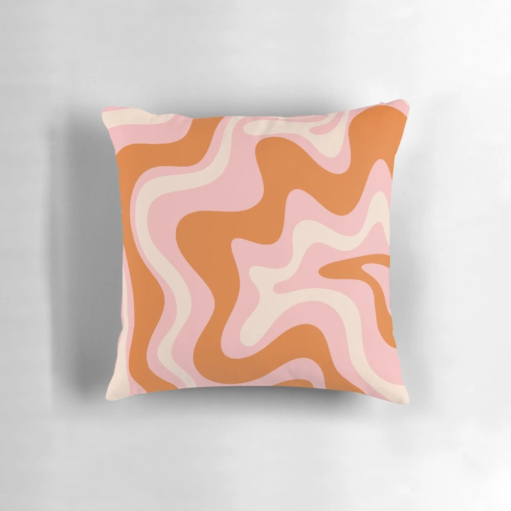 Retro abstract pattern in pink, orange, and cream colors on a decorative throw pillow