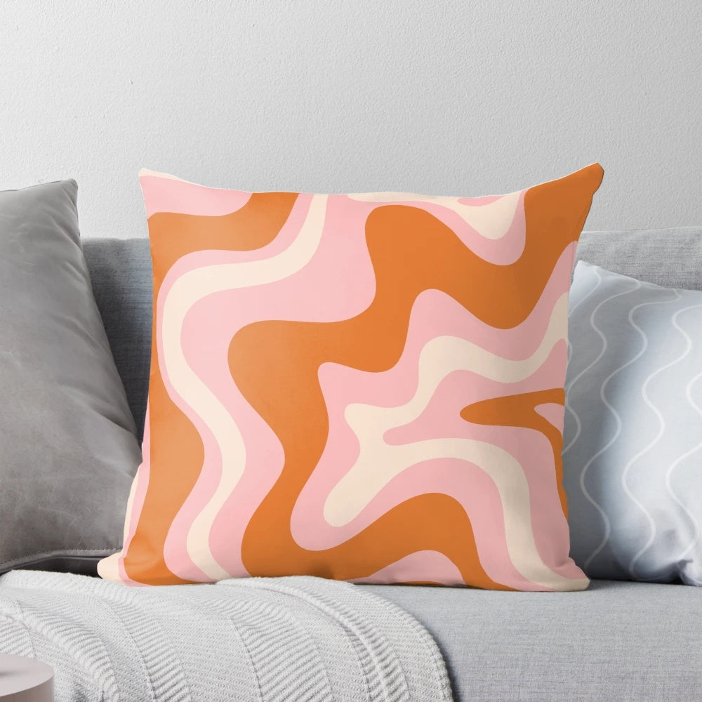 Retro abstract pattern in pink, orange, and cream colors on a decorative throw pillow