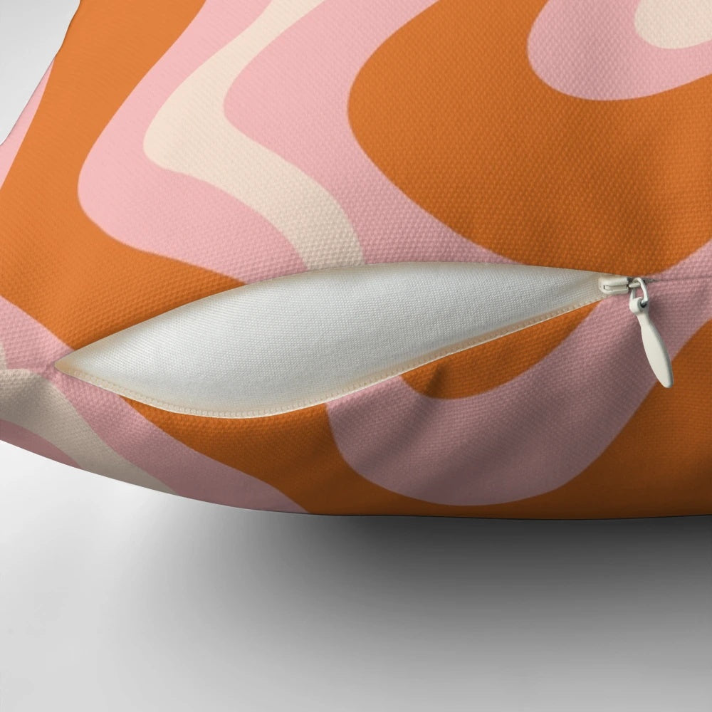 Retro abstract pattern in pink, orange, and cream colors on a decorative throw pillow