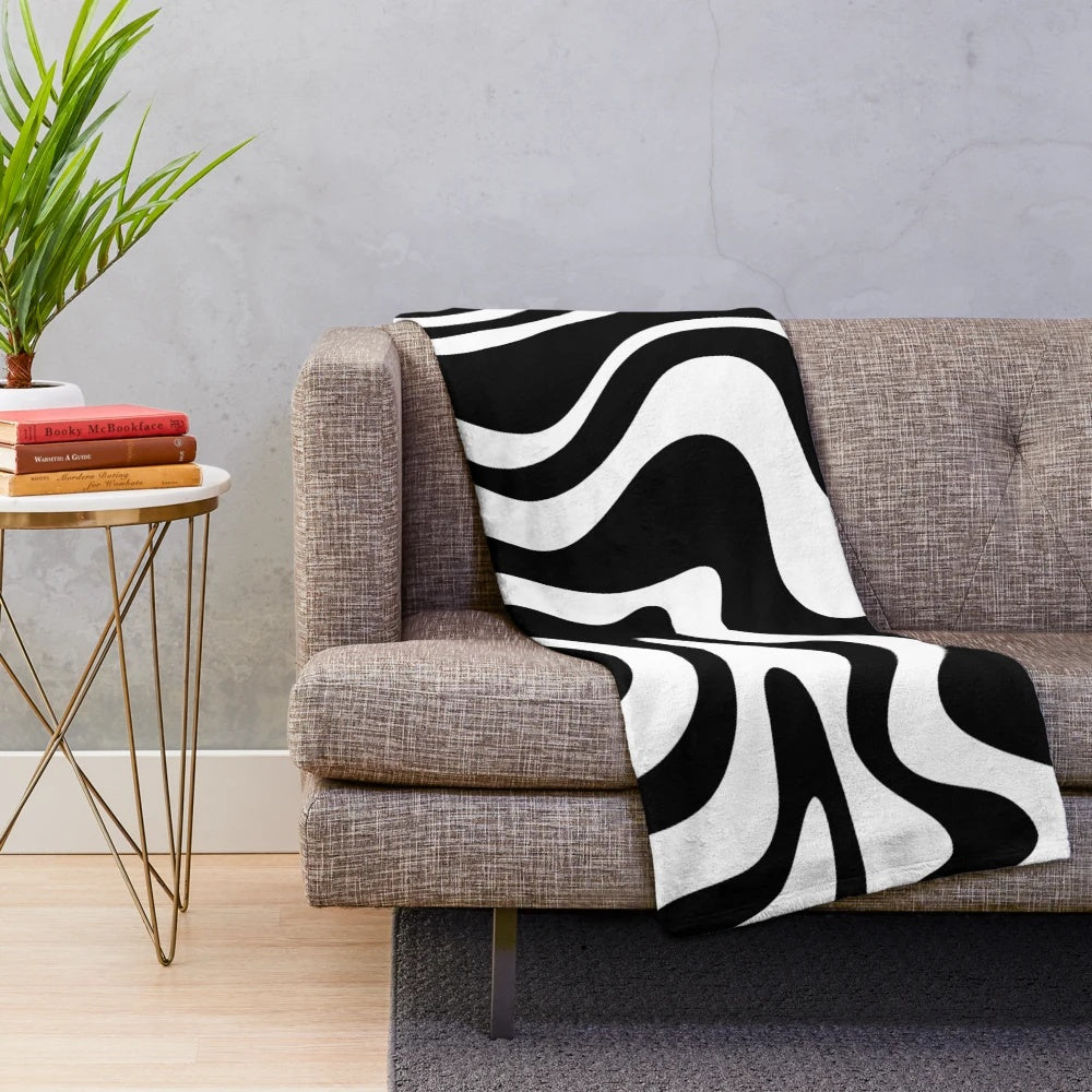 Retro abstract plush blanket with a trippy swirly pattern in black and white