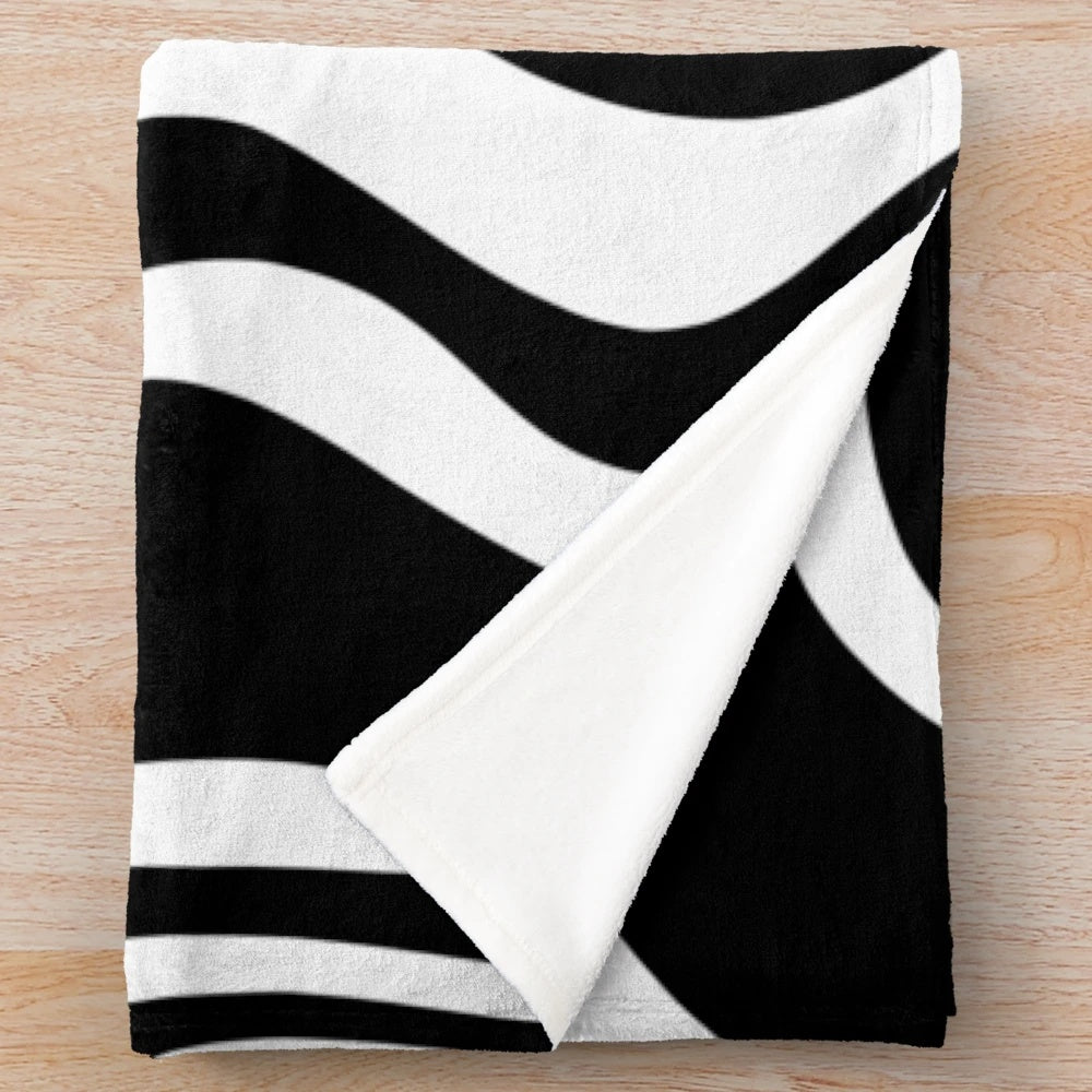 Retro abstract plush blanket with a trippy swirly pattern in black and white