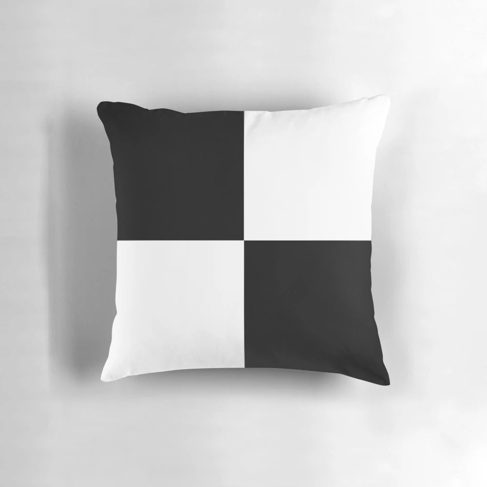 Black and white pillow with geometric checkered pattern and contrasting blocks