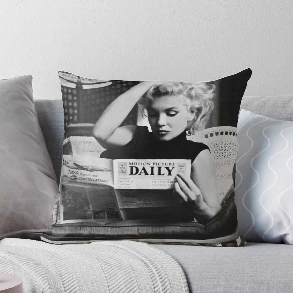 Retro black and white photograph of Marilyn Monroe reading a newspaper, featured on a decorative pillow.