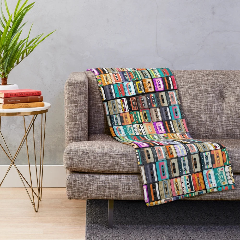 Cozy cassette tape plush blanket featuring a retro music design