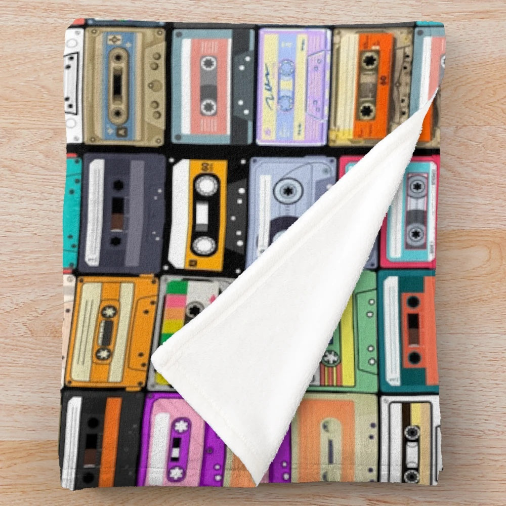 Cozy cassette tape plush blanket featuring a retro music design