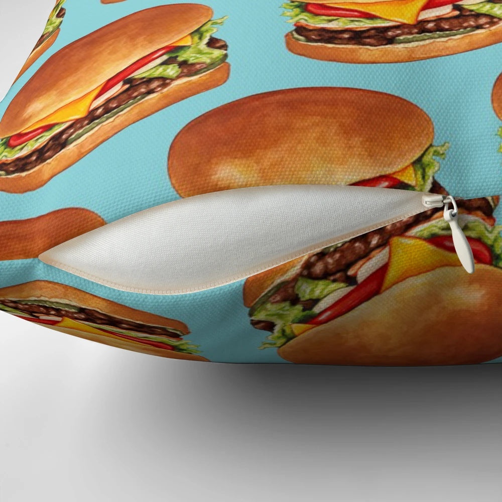 Blue pillow with a vibrant cheeseburger pattern, perfect for adding a retro touch to any space.