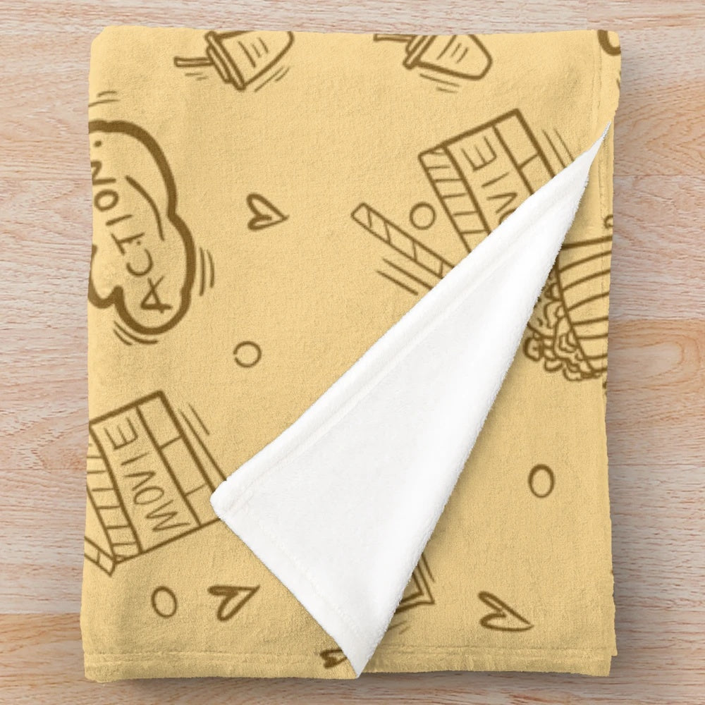 Plush blanket with a retro cinema-inspired pattern featuring movie elements like popcorn, cameras, and classic drinks.