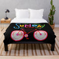 Retro-style plush blanket featuring a cycling design