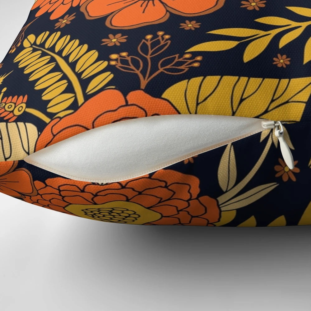 Retro floral 1970s pillow with a vintage flower and leaf design in shades of orange, yellow, brown, and navy.
