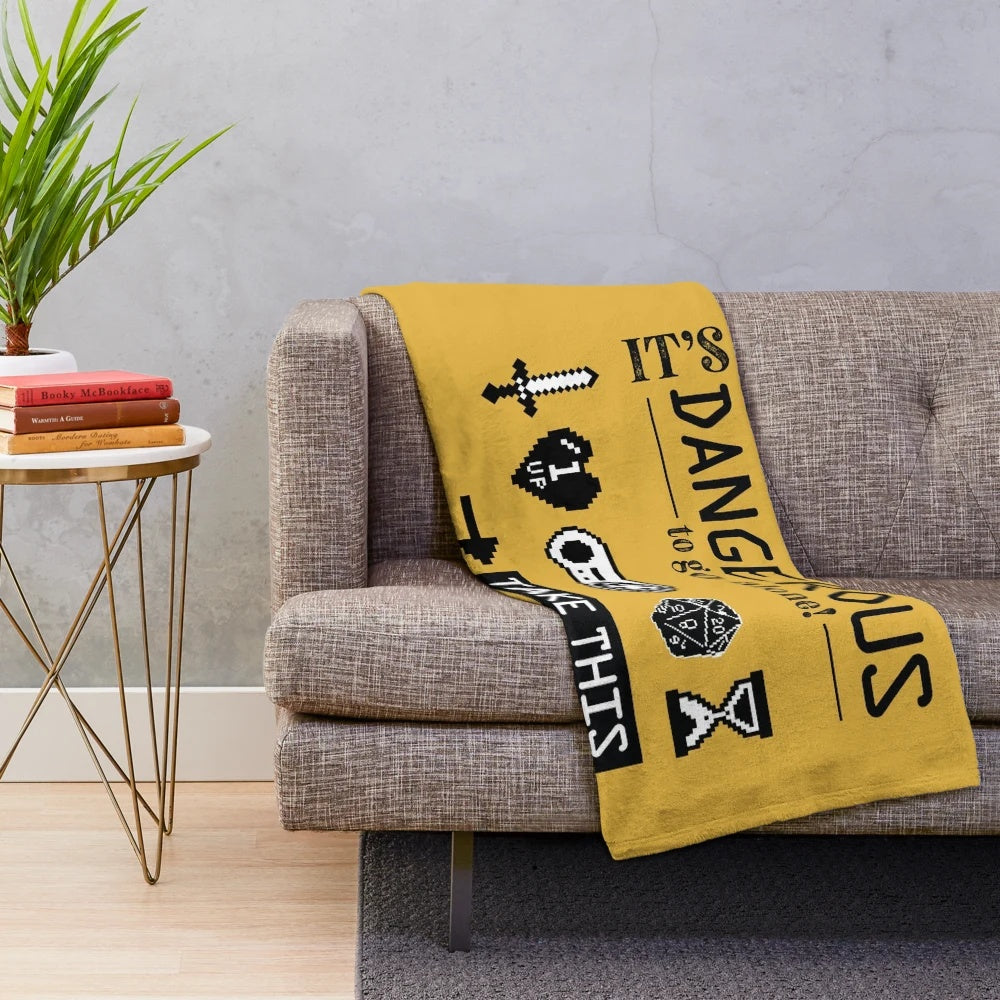 Plush blanket with gaming icons and "It's Dangerous to Go Alone" design