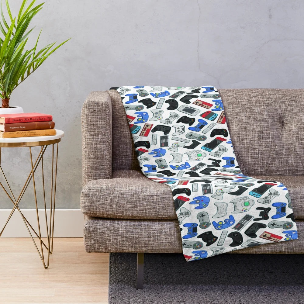 Cozy plush blanket featuring classic video game controllers design