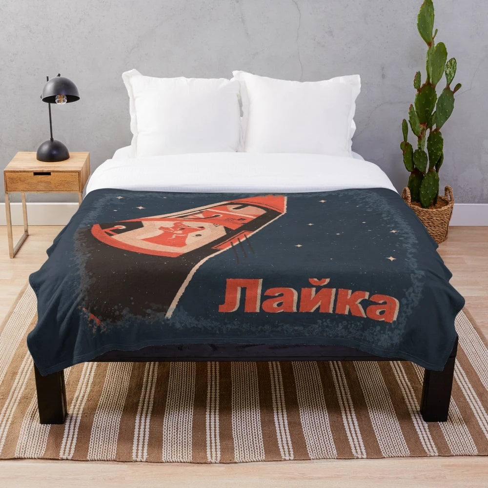 Plush blanket featuring an illustration of the famous Soviet space dog Laika on the Sputnik spacecraft