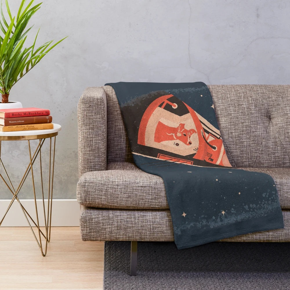 Plush blanket featuring an illustration of the famous Soviet space dog Laika on the Sputnik spacecraft