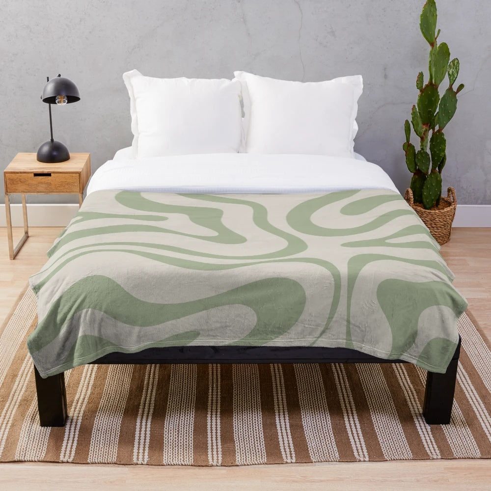 Plush blanket with abstract swirl pattern in beige and sage green