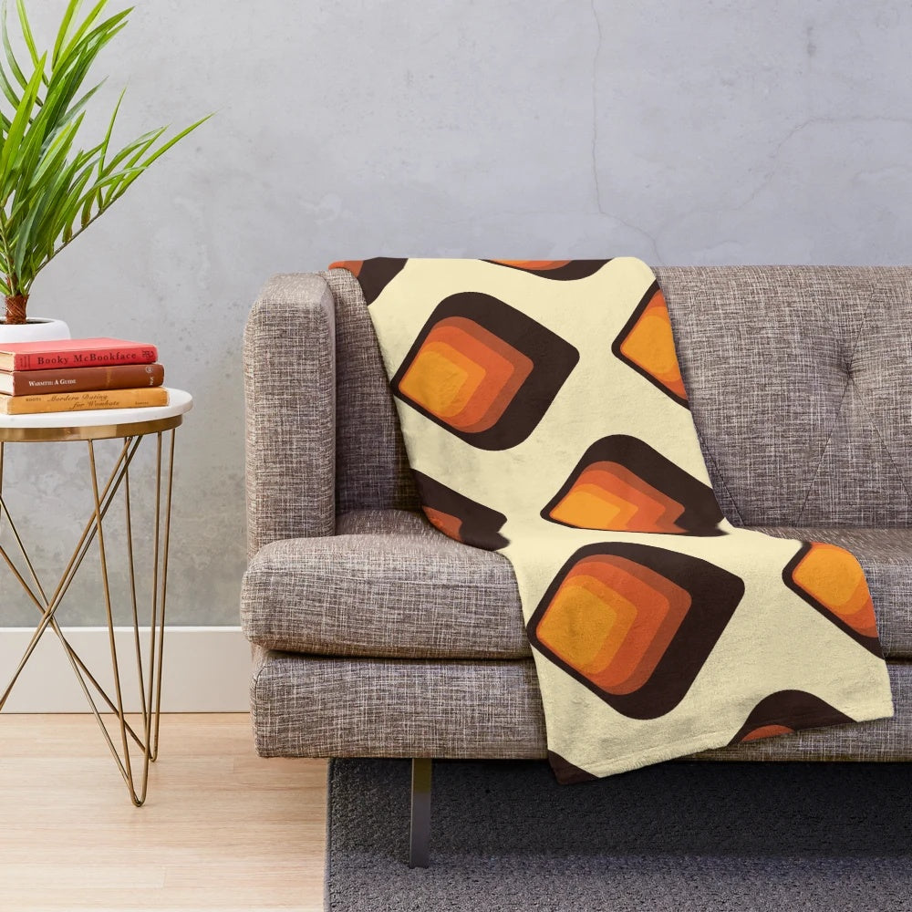 Mid-century modern style plush blanket with geometric tear drop pattern in orange and brown colors
