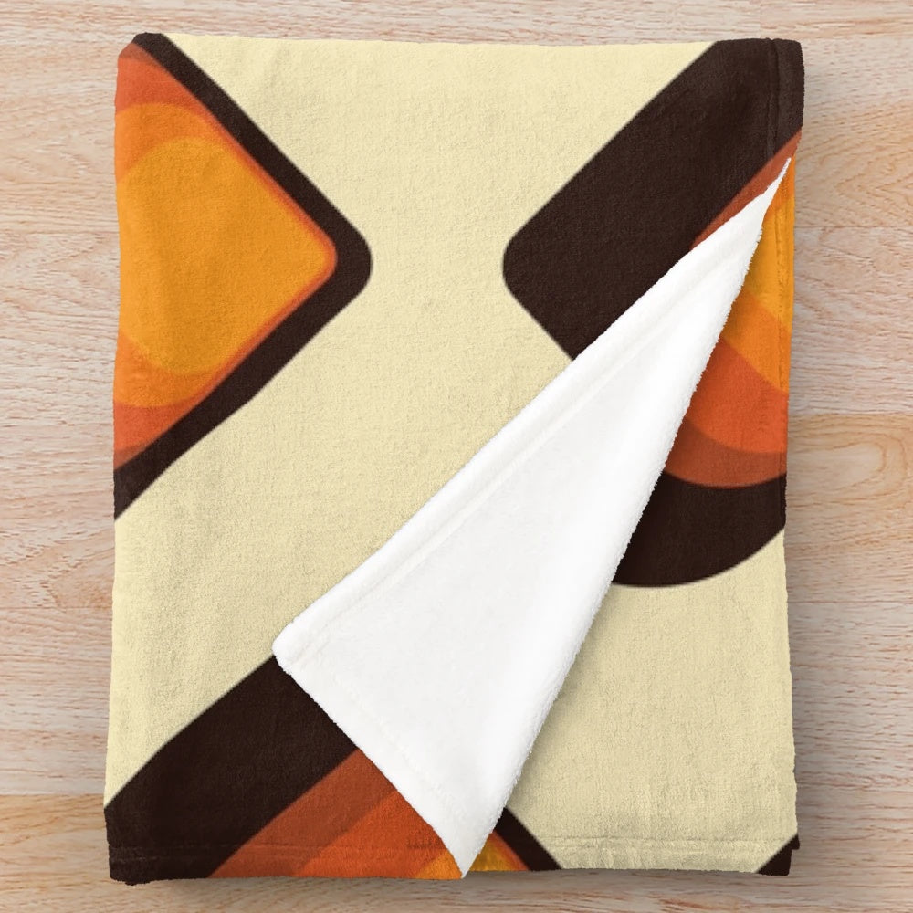 Mid-century modern style plush blanket with geometric tear drop pattern in orange and brown colors