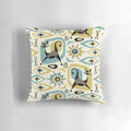 A vibrant mid-century style pillow featuring an abstract design with playful atomic-inspired cats in shades of blue, gold, and gray.