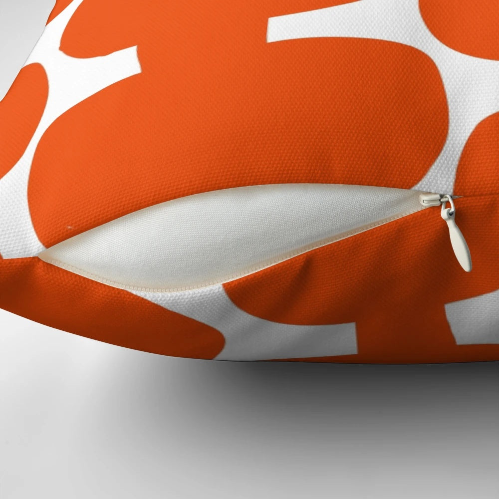 A white and orange mid century modern floral pattern pillow