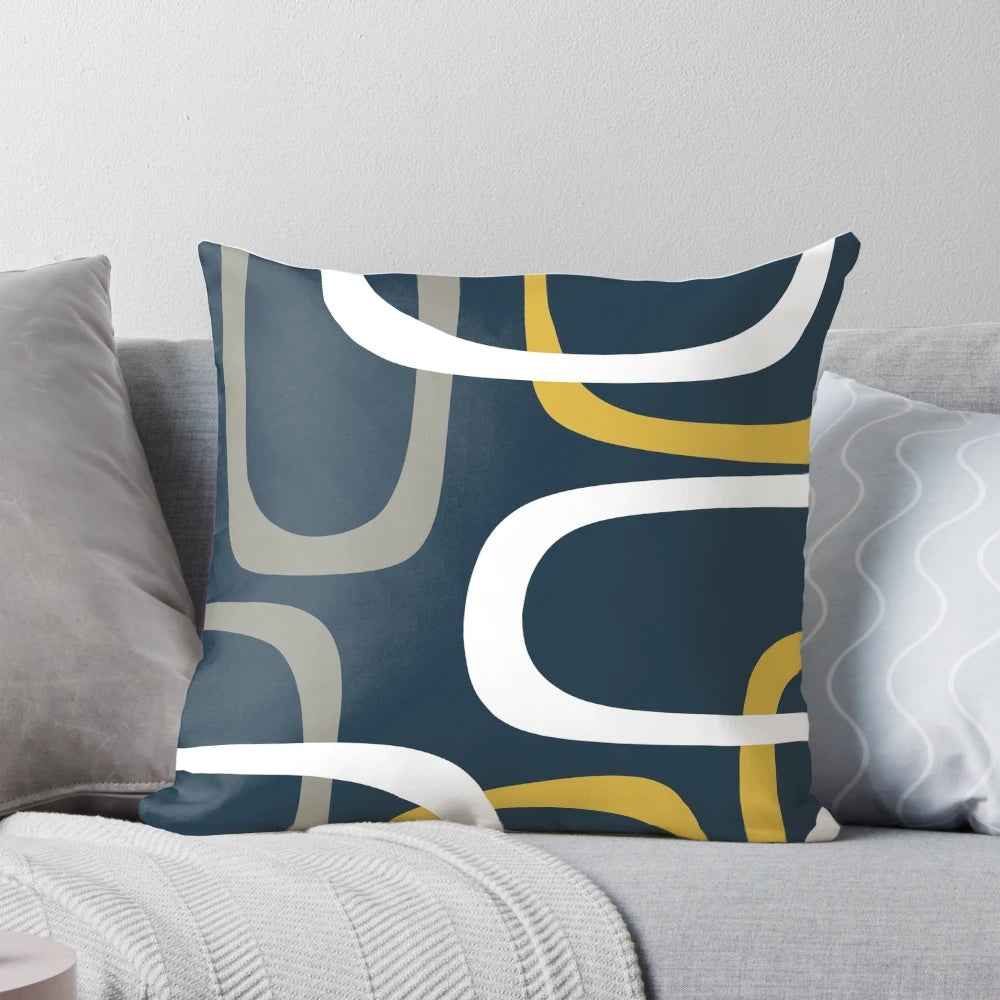 Midcentury modern inspired throw pillow with a geometric abstract pattern in light mustard, grey, white, and navy blue.